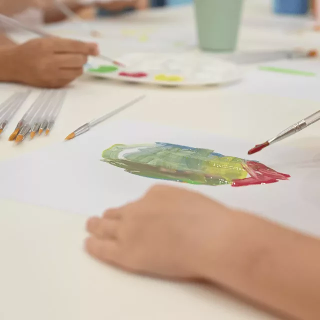 Children painting and having fun in childcare center Kids Club