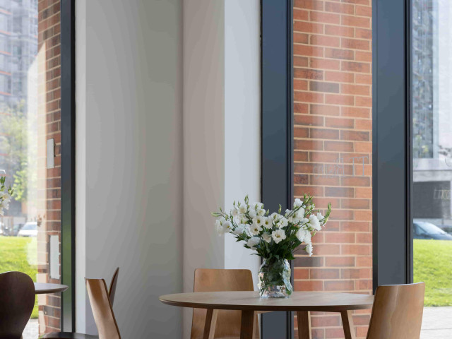 TT Bistro_restoran-min Sto sa cvećem u TT Bistro-u sa pogledom na okruženje.