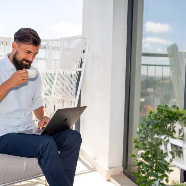 A man works on the terrace of his apartment in Belgrade Waterfront.