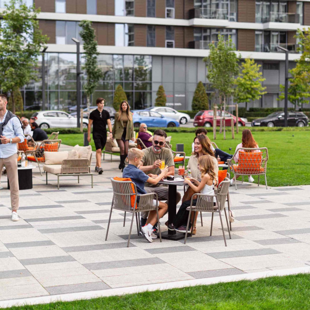 kafić-beograd-na-vodi_2 Residents of Belgrade Waterfront enjoying a family afternoon in Sava Park with refreshing beverages, surrounded by greenery.